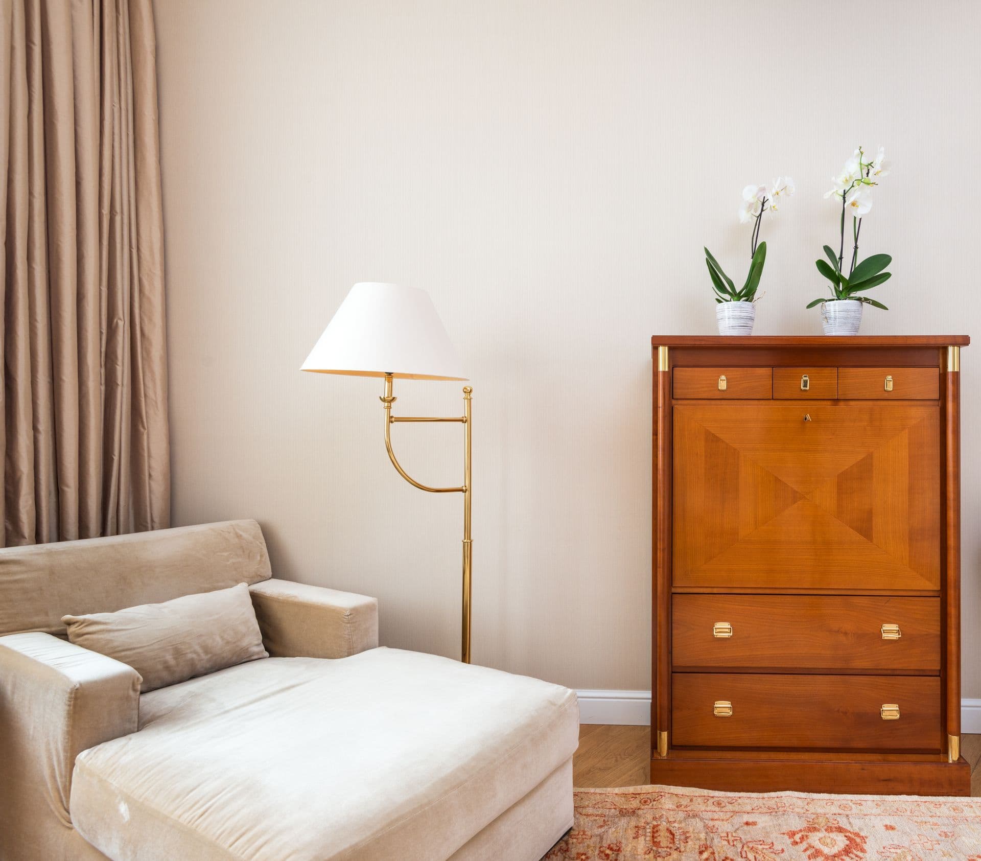 Soft beige interior with an armchair and orchids