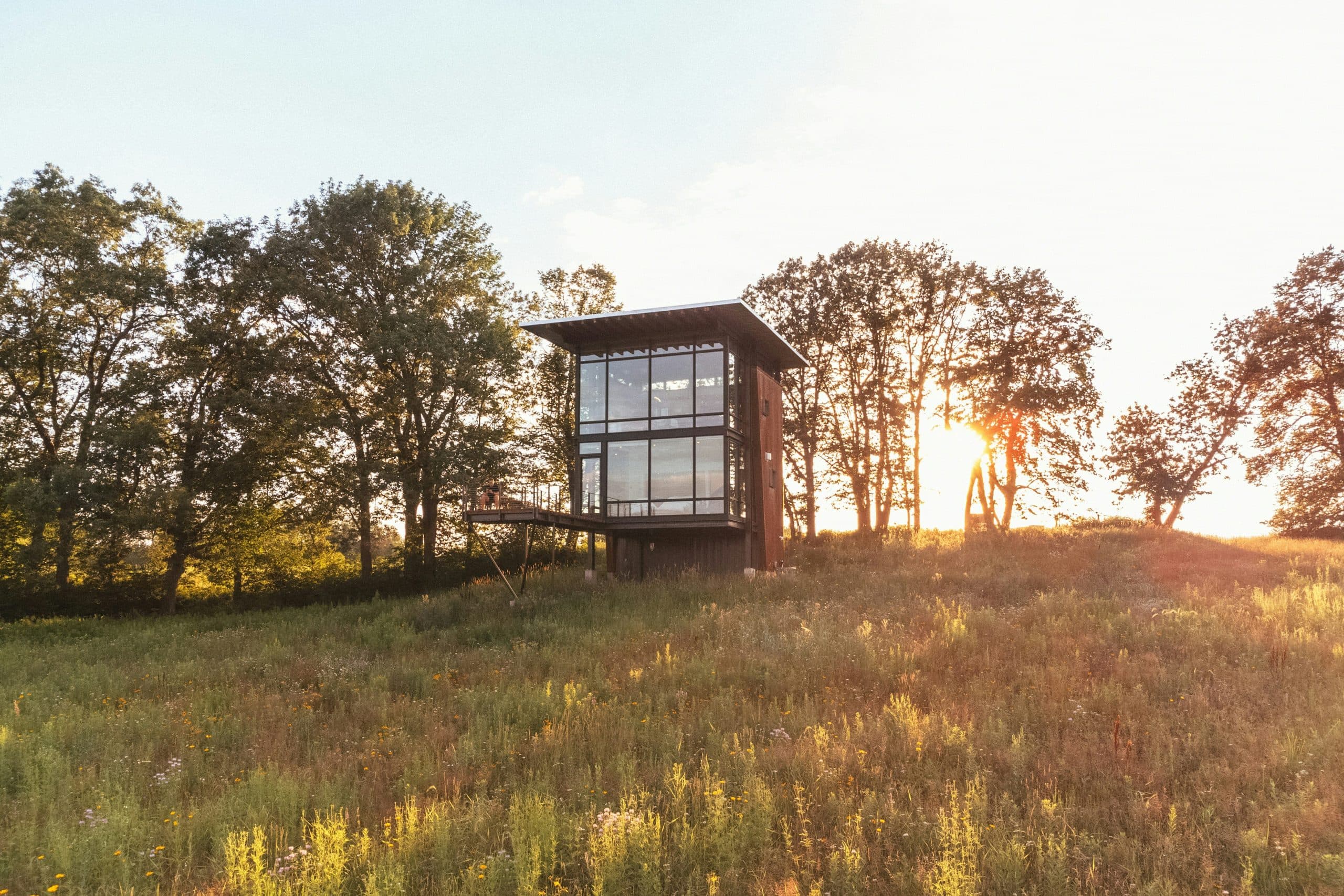 Maison vitrée dans la campagne au coucher du soleil